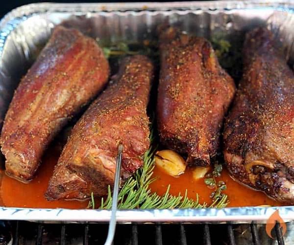 Bandeja de aluminio con 4 patas de cordero, caldo y hierbas